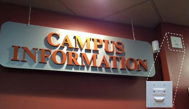 Gunshot detection sensor mounted on wall next to sign
